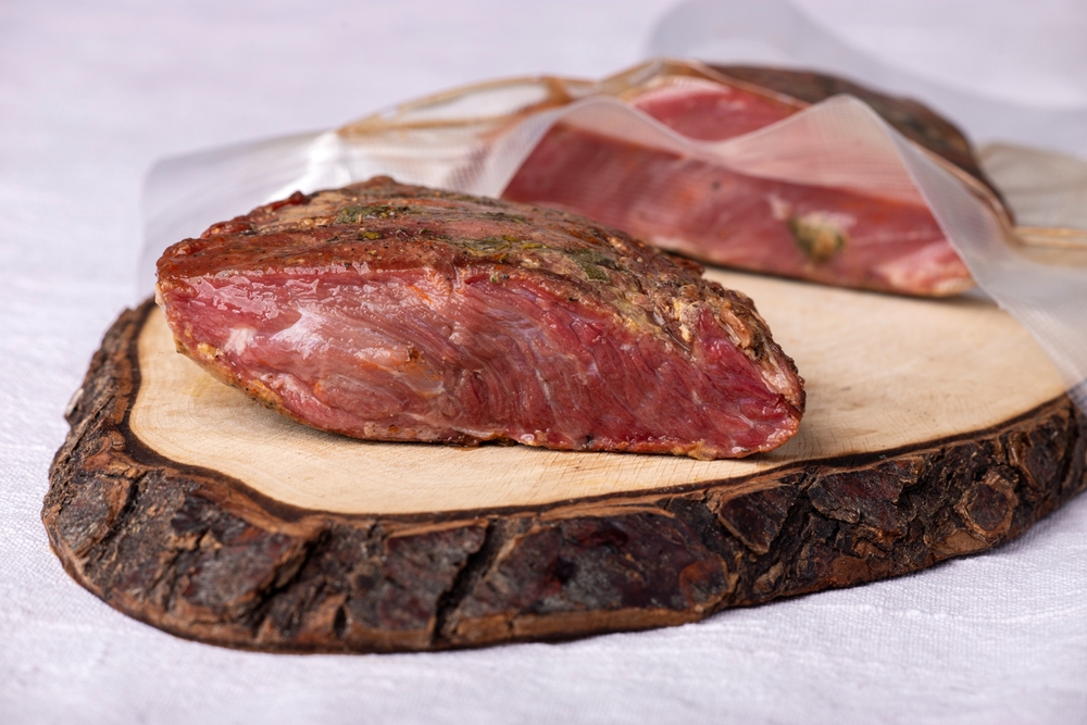 Two piece of meat that have been sous vide. One is still in a vacuum packaging bag.
