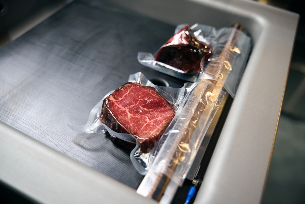 Two pieces of meat being vacuum packaged in preparation to sous vide.