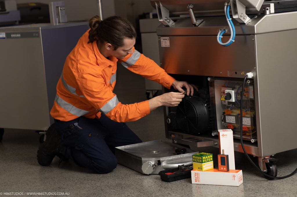 A technician performing maintenance on a Henkelman machine. 