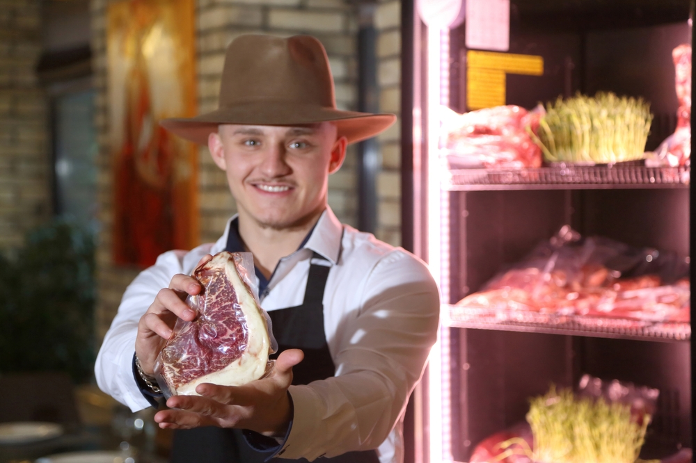 A local Australian butcher holding up a piece of vacuum sealed meat.