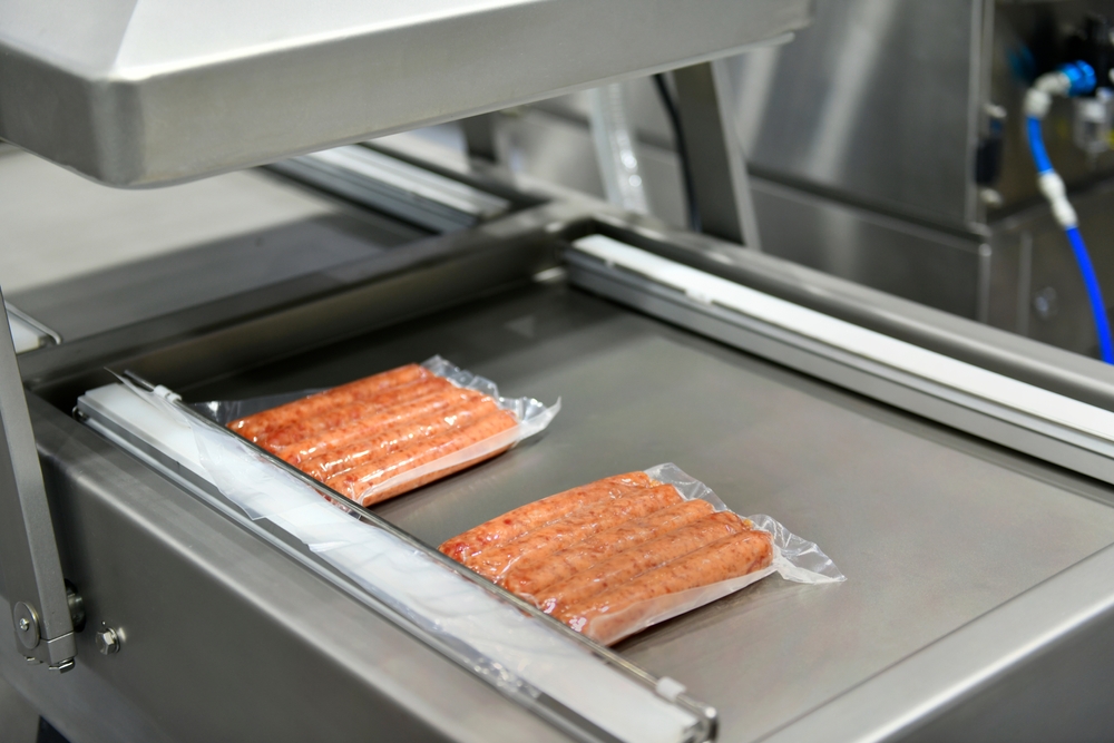 Packs of sausages vacuum sealed in a double chamber vacuum packing machine.