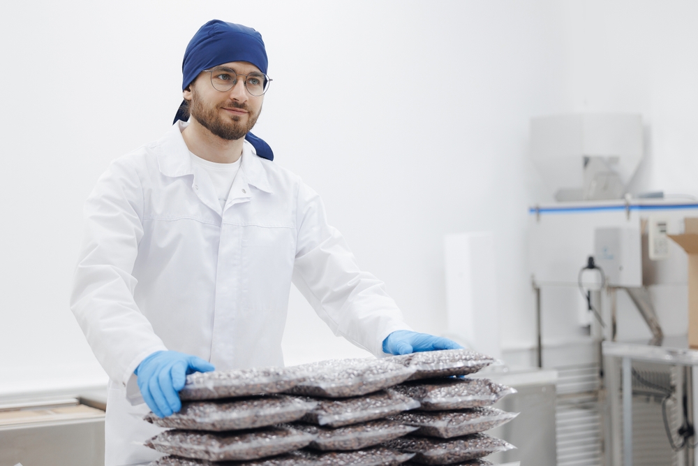 A food processing working quality checking the packaging of products.